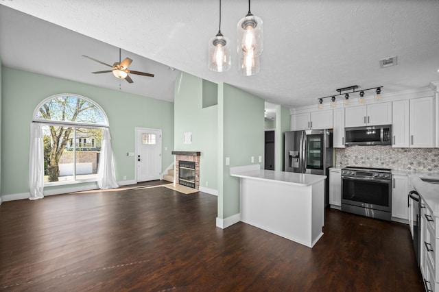 1829 Apple Valley Cir, Nashville, TN 37207 - kitchen featuring open floor plan, white cabinetry, stainless steel appliances, backsplash, and a tile fireplace