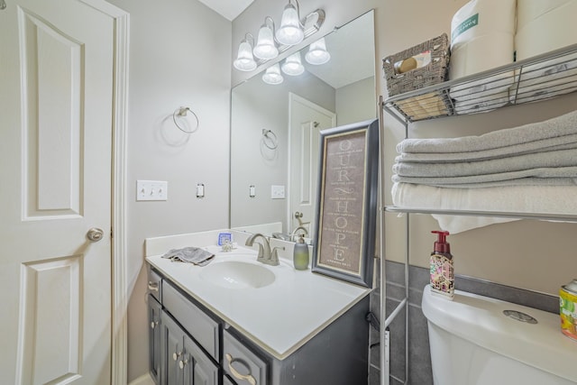 half bath featuring vanity and toilet