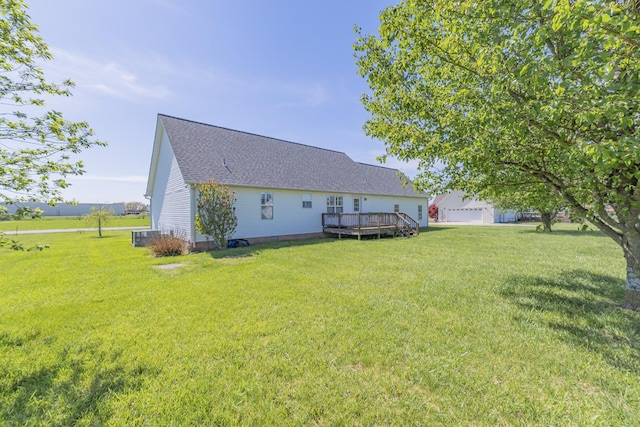 rear view of house with a shingled roof, crawl space, a wooden deck, and a lawn