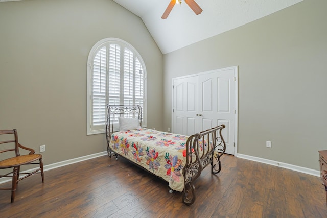 bedroom with a closet, baseboards, wood finished floors, and lofted ceiling