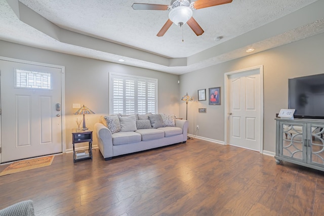 living room with ceiling fan, baseboards, wood finished floors, and a textured ceiling