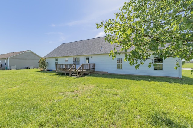 back of property with a yard and a wooden deck