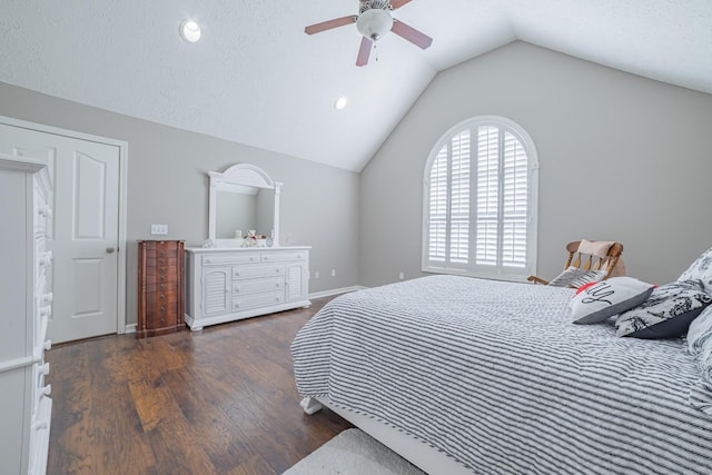 bedroom with baseboards, vaulted ceiling, a textured ceiling, a ceiling fan, and wood finished floors