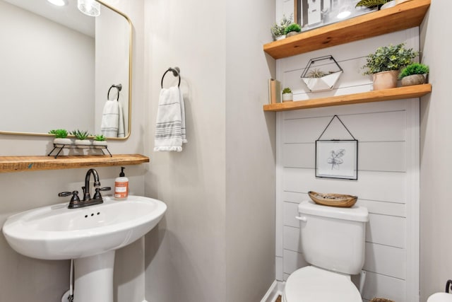 half bath with toilet and a sink