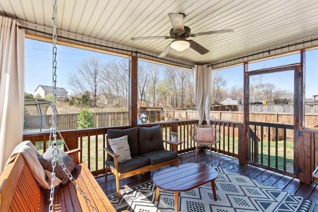 sunroom featuring plenty of natural light, ceiling fan, and an outdoor hangout area