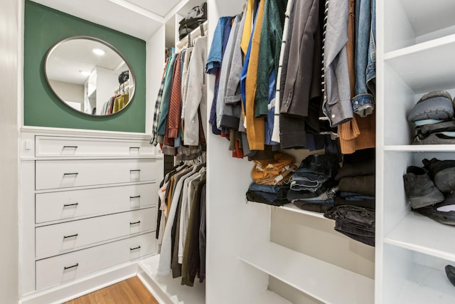 walk in closet with wood finished floors