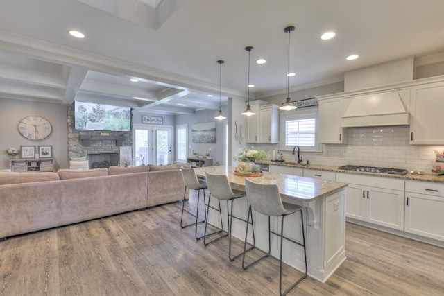 127 Waters Hill Cir, Lebanon, TN 37087 - kitchen featuring open floor plan, light wood-type flooring, a kitchen bar, and decorative backsplash