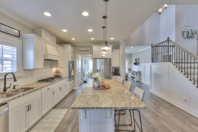 127 Waters Hill Cir, Lebanon, TN 37087 - kitchen with a sink, light wood finished floors, white cabinetry, stainless steel appliances, and decorative backsplash