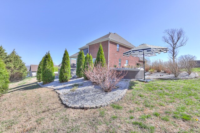 127 Waters Hill Cir, Lebanon, TN 37087 - view of home's exterior with a jacuzzi, a lawn, cooling unit, and brick siding