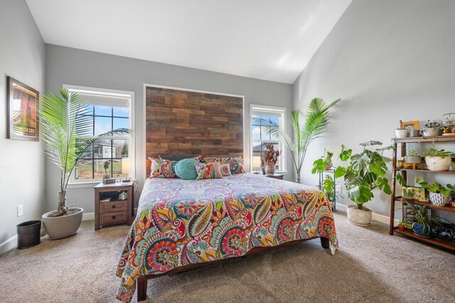 carpeted bedroom with baseboards and vaulted ceiling