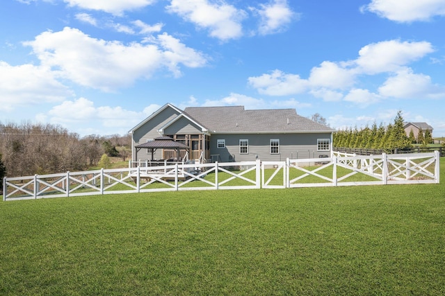 back of house featuring a lawn, a gate, a fenced backyard, and a gazebo