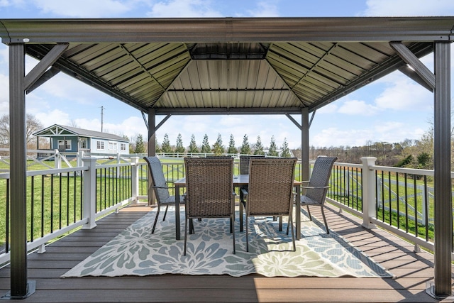 wooden terrace with outdoor dining space, a gazebo, and a lawn