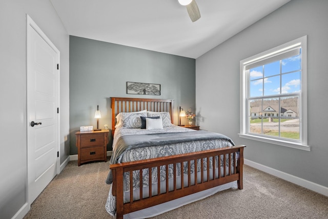 carpeted bedroom featuring baseboards and a ceiling fan