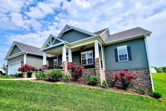 craftsman-style home featuring an attached garage, a porch, and a front yard