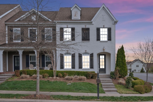 view of front facade with a porch and brick siding