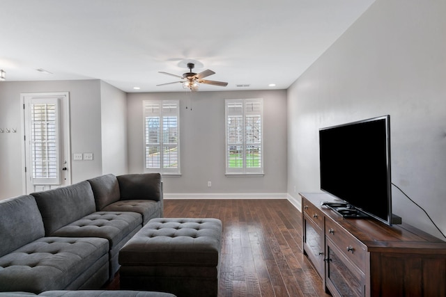 living room with a wealth of natural light, dark wood-style flooring, baseboards, and a ceiling fan