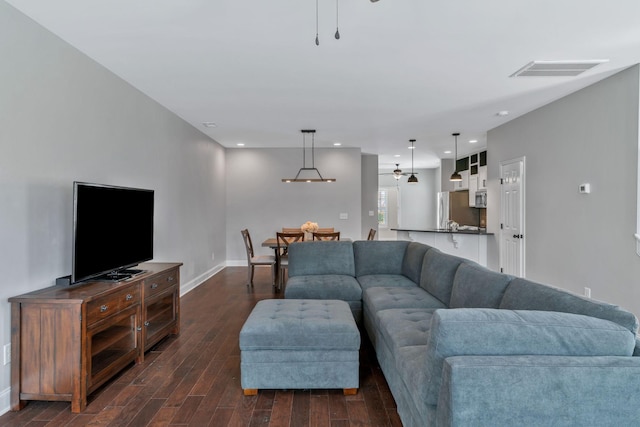living area with dark wood-style flooring, visible vents, baseboards, and recessed lighting