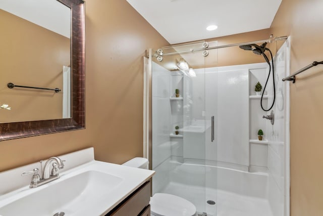 full bath with toilet, vanity, and a stall shower