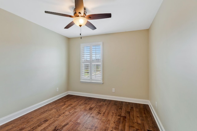 empty room with dark wood-style floors, baseboards, and a ceiling fan