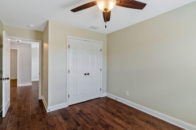 unfurnished bedroom with ceiling fan, dark wood finished floors, a closet, visible vents, and baseboards