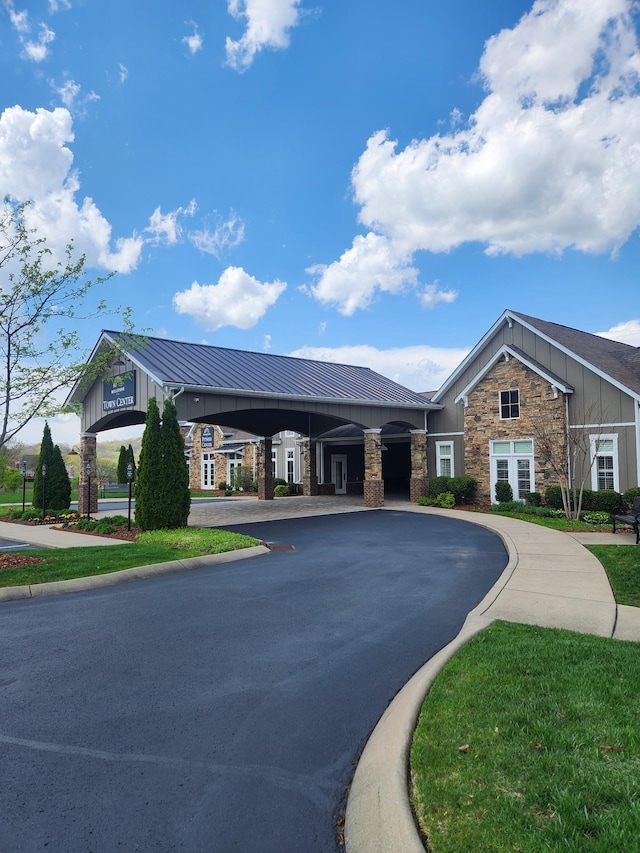 view of property with a carport and curved driveway