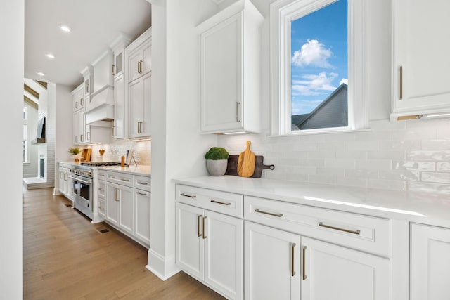 kitchen with white cabinetry, plenty of natural light, light countertops, and double oven range