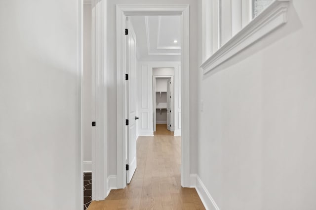 corridor featuring baseboards and light wood finished floors
