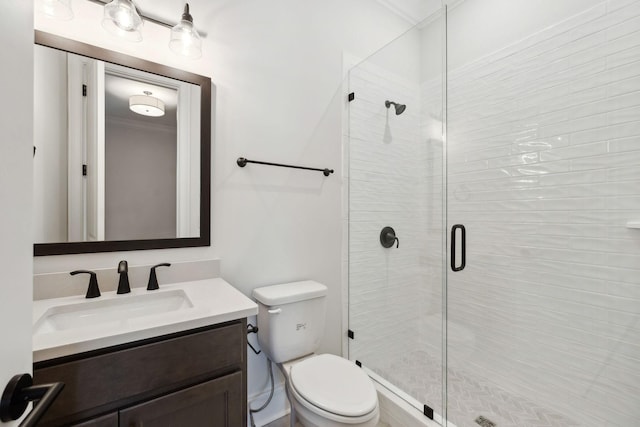 bathroom with toilet, vanity, and a shower stall