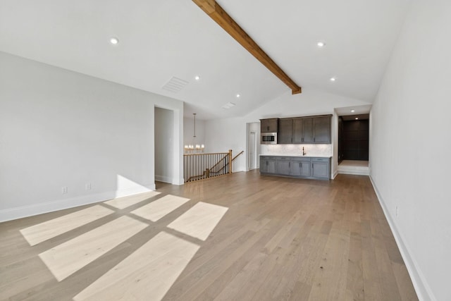 unfurnished living room featuring a chandelier, vaulted ceiling with beams, baseboards, visible vents, and light wood-style floors
