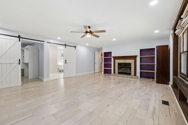 3755 Bear Hollow Rd, Joelton, TN 37080 - unfurnished living room featuring a barn door, ceiling fan, recessed lighting, and light wood finished floors