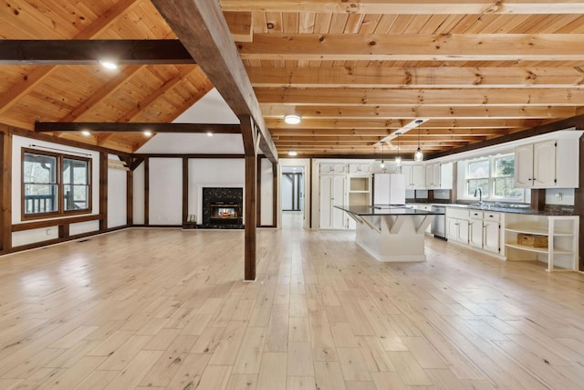 3755 Bear Hollow Rd, Joelton, TN 37080 - unfurnished living room featuring wooden ceiling, a sink, light wood-style flooring, vaulted ceiling with beams, and a fireplace