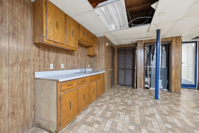 3755 Bear Hollow Rd, Joelton, TN 37080 - kitchen featuring light countertops, brown cabinets, a paneled ceiling, and wood walls