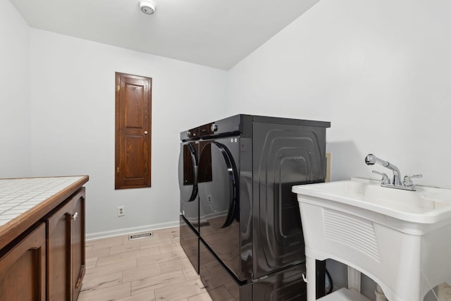 3755 Bear Hollow Rd, Joelton, TN 37080 - clothes washing area with baseboards, separate washer and dryer, a sink, visible vents, and cabinet space