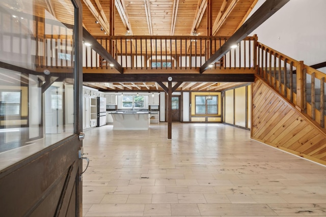 3755 Bear Hollow Rd, Joelton, TN 37080 - unfurnished living room with wood ceiling, stairway, light wood finished floors, wooden walls, and a towering ceiling