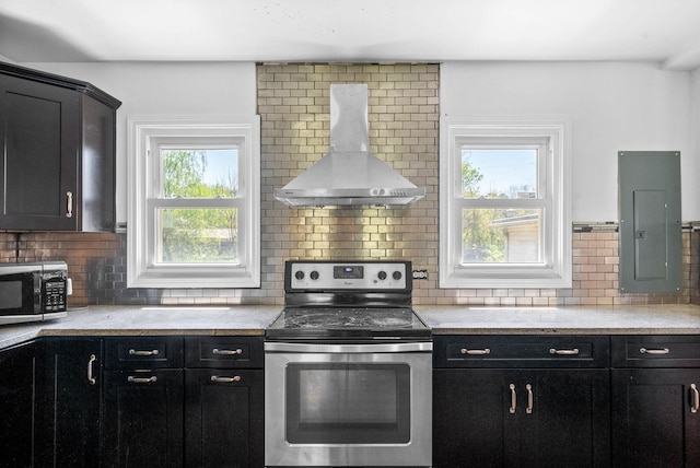kitchen with electric panel, electric stove, range hood, and dark cabinets