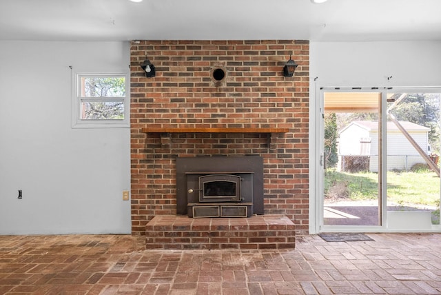 unfurnished living room featuring brick floor and a brick fireplace