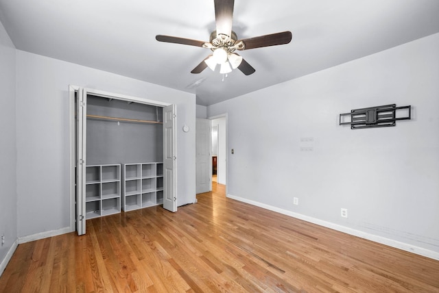 unfurnished bedroom with wood finished floors, baseboards, a closet, and a ceiling fan