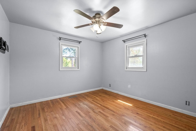 unfurnished room featuring baseboards, a ceiling fan, light wood-style floors, and plenty of natural light