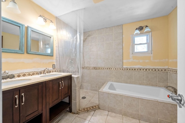 bathroom with double vanity, a garden tub, tile patterned floors, and a sink