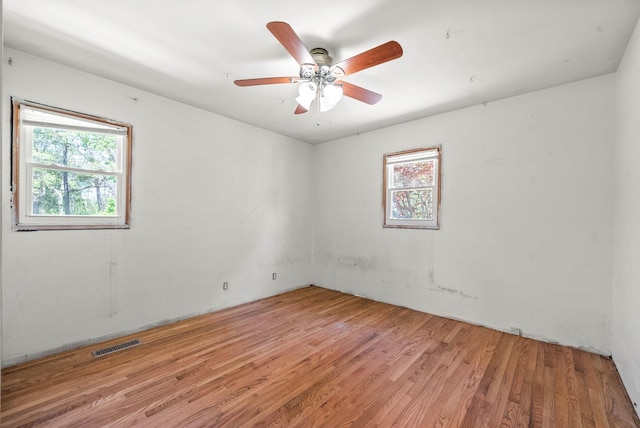 empty room with light wood-style flooring, visible vents, and a ceiling fan