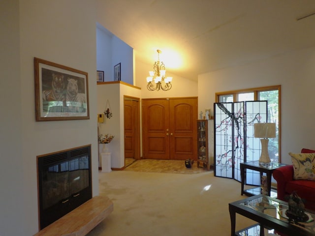 carpeted entrance foyer with a glass covered fireplace and a chandelier