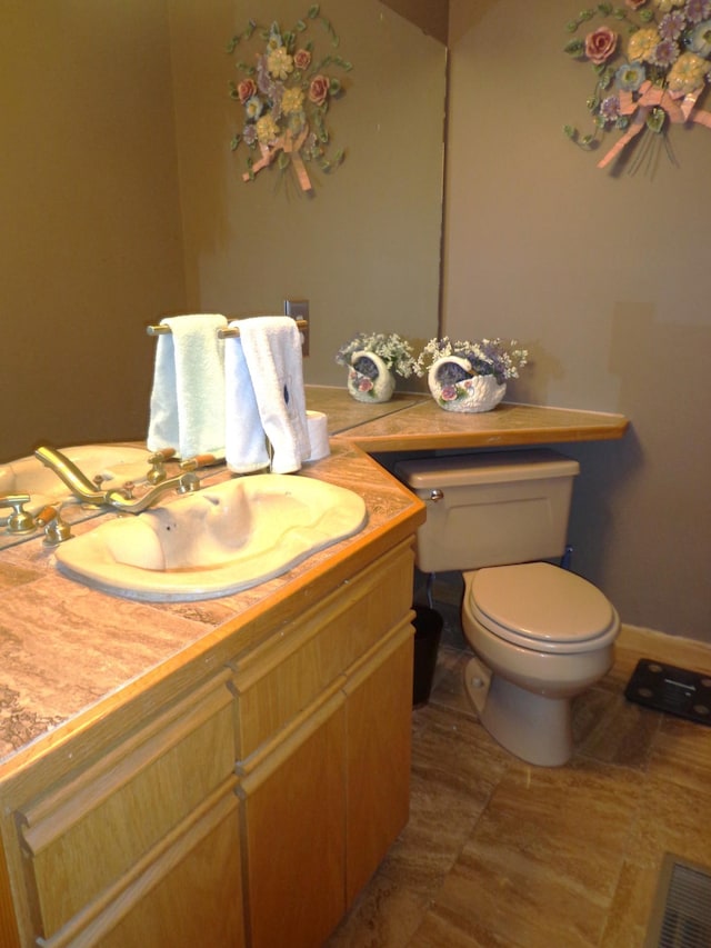 bathroom with baseboards, visible vents, toilet, and vanity