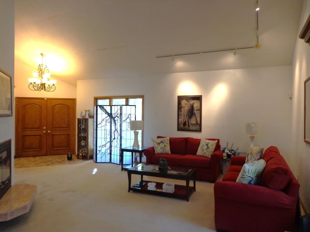 living room with track lighting, carpet, and a chandelier