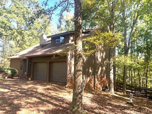 exterior space with driveway, fence, and a chimney