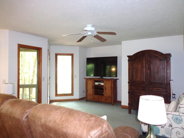 living room with baseboards, a ceiling fan, and light carpet