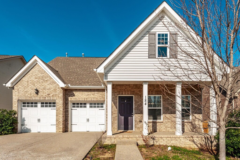 184 Bexley Way, White House, TN 37188 - view of front of house with driveway, a shingled roof, a garage, and brick siding