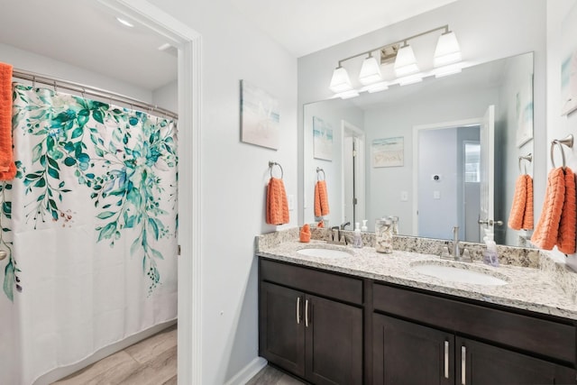 7403 Hemen Way, Fairview, TN 37062 - bathroom featuring baseboards, double vanity, a sink, and wood finished floors