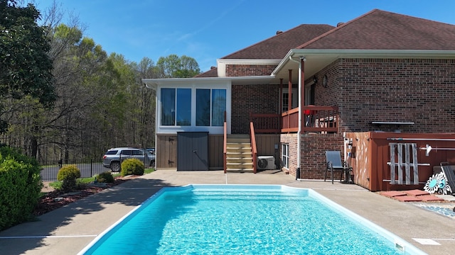 view of pool with a sunroom, fence, stairway, a patio, and a fenced in pool