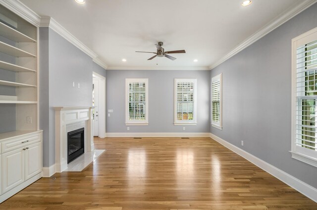 unfurnished living room with a high end fireplace, light wood-style floors, ceiling fan, and recessed lighting