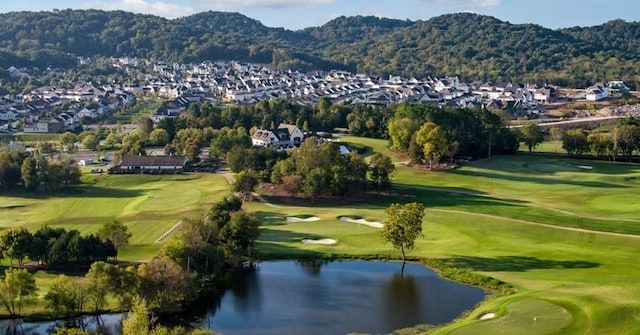 drone / aerial view with a residential view, golf course view, and a water and mountain view